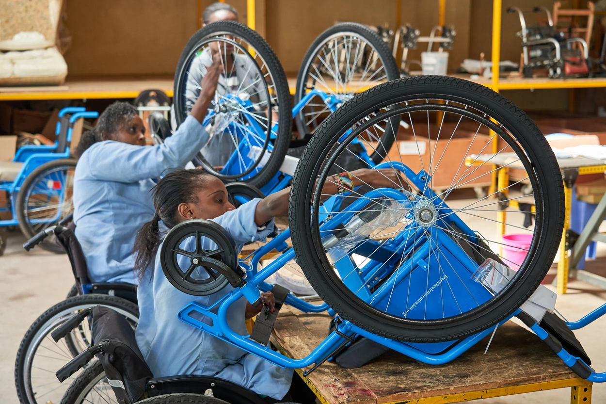 Workers in a workshop in Kenya, who are wheelchair users themselves, are assembling wheelchairs for local distribution. Photo credit: Walkabout Foundation.
